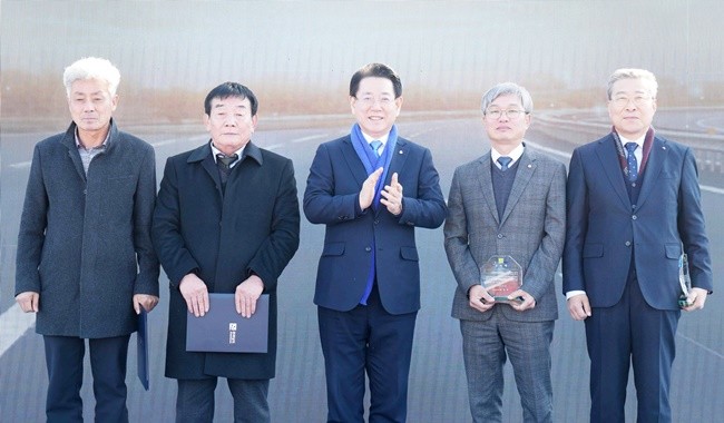 김영록 전라남도지사가 13일 장흥 장평면에서 열린 ‘장흥 유치~이양 간 지방도 확·포장공사 개통식’에서 유공자에게 표창장을 수여한 뒤 기념촬영을 하고 있다.