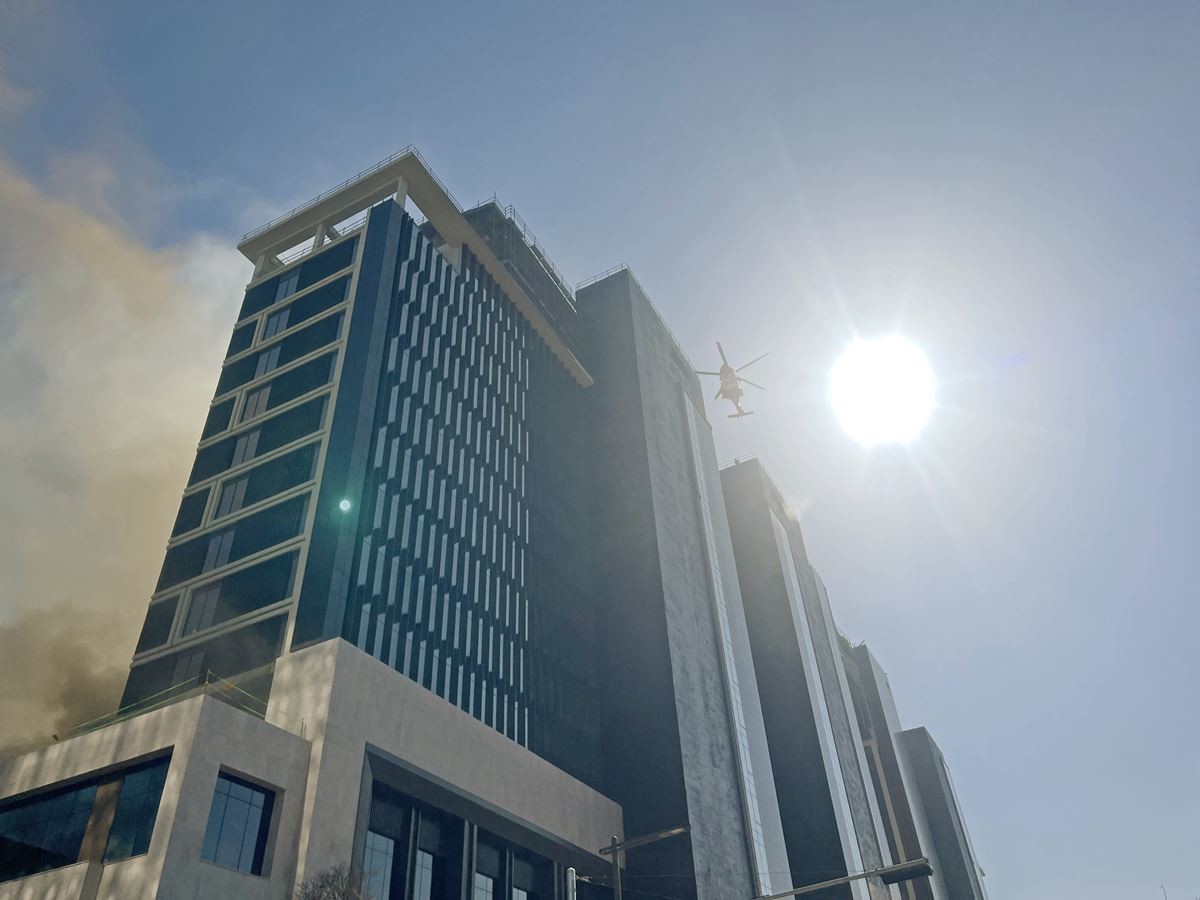 부산 반얀트리 호텔 공사현장 위로 날아가는 소방헬기 / 뉴스1 (부산경찰청 제공)