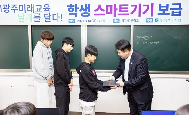 18일 광주서석중에서 있었던 ‘교육용 스마트 기기 전달식’에서 이정선 교육감이 학생에게 노트북을 전달하고 있다.