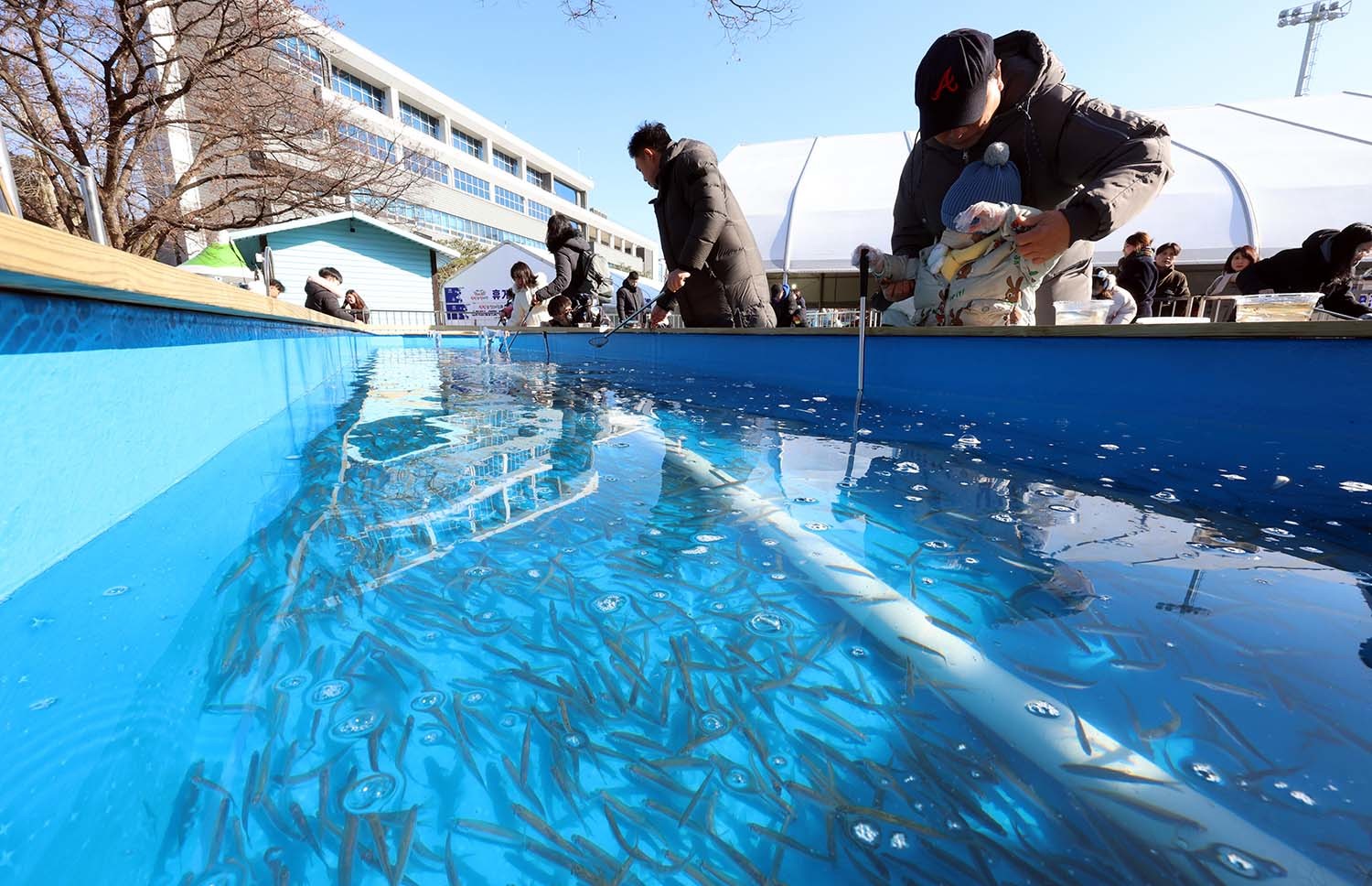 2024년 12월 26일 서울 노원구 서울과학기술대학교 내 종합운동장에서 개장된 '2025 노원 눈썰매장'에서 가족들이 빙어잡이 체험을 하며 즐거운 시간을 보내고 있다. / 뉴스1 자료사진