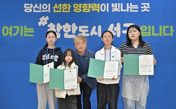 김이강 광주 서구청장이 12일 서구청 들불홀에서 열린 '제10기 서구 청소년구정참여단 발대식'에서 위촉장을 수여한 후 참석자들과 기념촬영을 하고 있다./ 광주 서구 제공