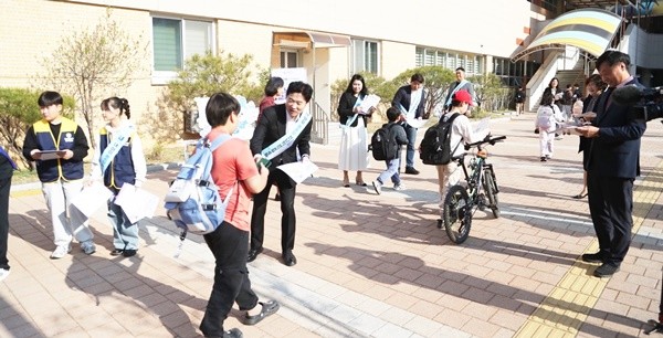 전남교육청 관계자들이 등교하는 신대초등학교 학생들에게 전남학생교육수당 활용법 리플릿을 나눠주고 있다.