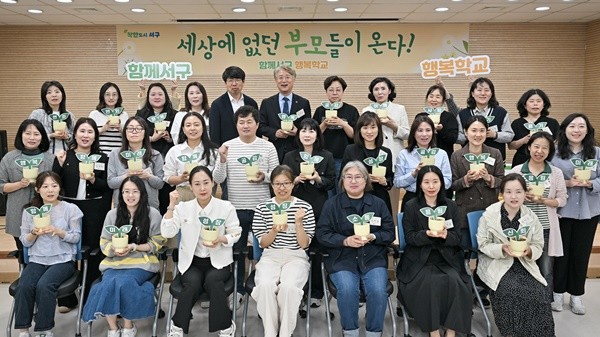 김이강 광주 서구청장이 24일 서구 화정청소년문화의집 멀티플레이실에서 열린 '함께서구 행복학교 1기 입학식'에서 행복, 성장, 미래 등 문구가 적힌 희망의 화분을 들고 참석자들과 기념촬영을 하고 있다. 광주 서구 제공
