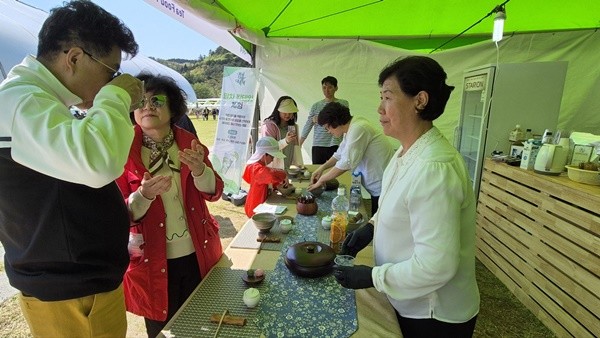 관광객들이 한국차문화공원 잔디광장에서 말차 칵테일 체험을 하고 있다.