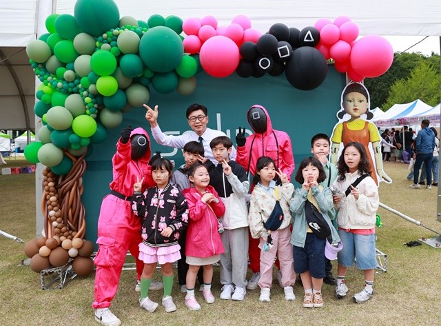 김철우 군수와 어린이들이 함께 오징어게임 포토존에서 사진 촬영을 하고 있다.