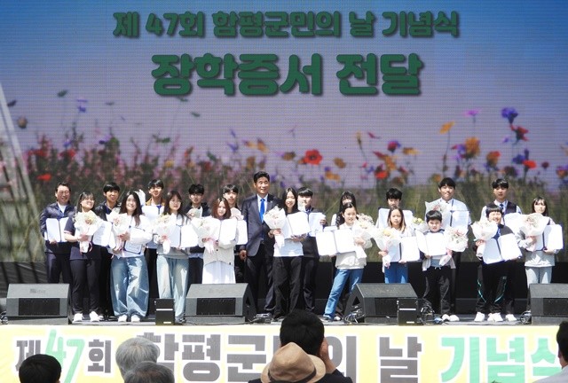 오민수 함평군번영회장이 장학금을 수여하고 학생들과 기념촬영을 하고 있다.