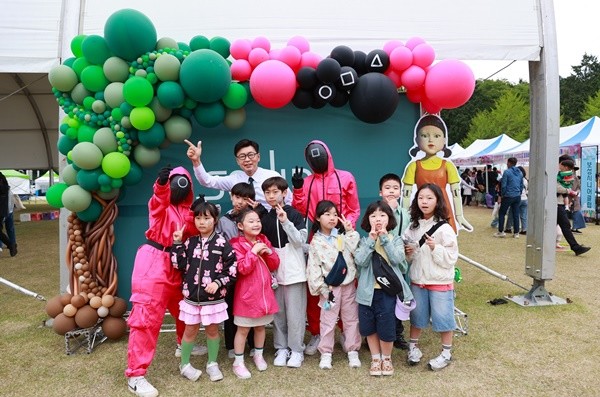 김철우 군수와 어린이들이 함께 오징어게임 포토존에서 사진 촬영을 하고 있다