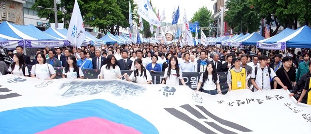 김영록 전라남도지사를 비롯한 강기정 광주광역시장 등 시민들이 17일 오후 광주 동구 금남로에서 5·18 전야제 행사 중 하나인 민주평화대행진을 펼치고 있다.