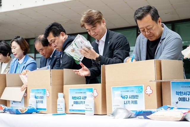 김이강 광주 서구청장이 9일 서구청 광장에서 열린 '희망여름, 착!착!착! 기획사업 및 나눔캠페인'에서 이기영 배우 등 참석자들과 여름나기 꾸러미를 만들고 있다. 광주 서구 제공