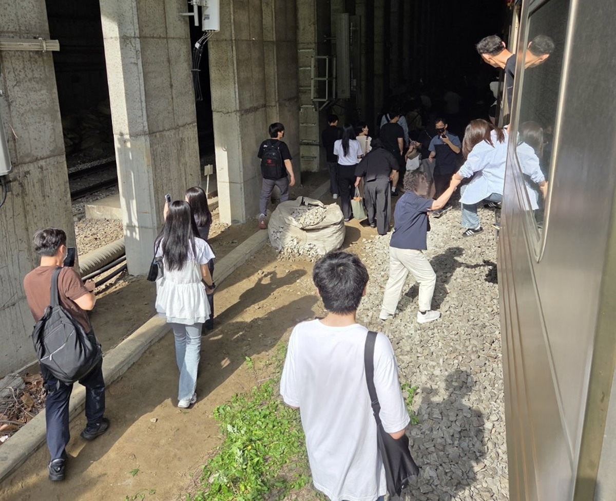 13일 오전 경의중앙선 신촌역 인근에서 서울역행 경의중앙선 열차가 단전으로 인해 신촌역 앞 50m지점에서 멈취 승객들이 열차에서 내려 신촌 역으로 걸어가고 있다. / 뉴스1