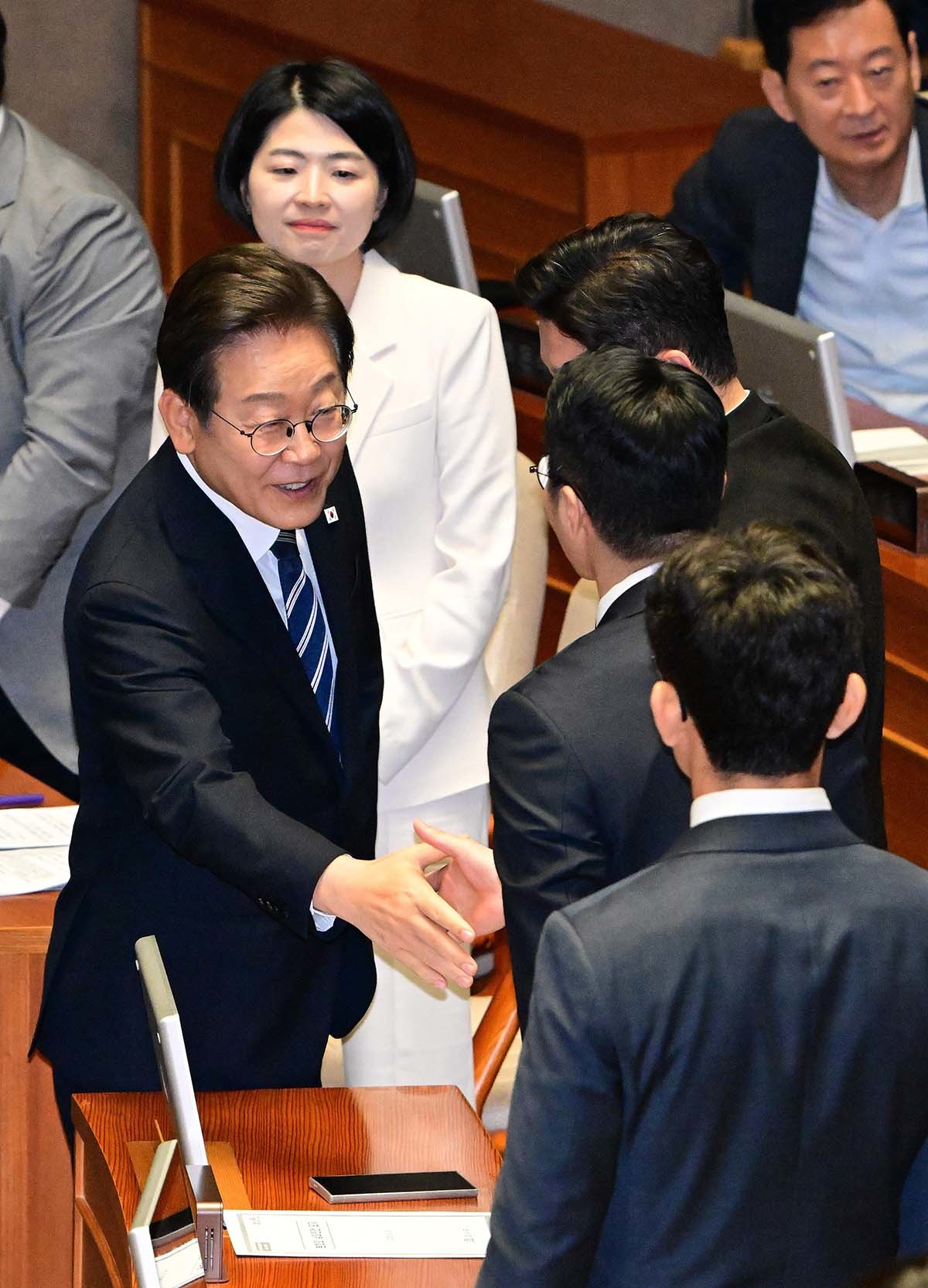 이재명 대통령이 26일 서울 여의도 국회에서 열린 추가경정예산안 시정연설을 마친 뒤 국민의힘 의원들과 인사를 나누고 있다. / 뉴스1