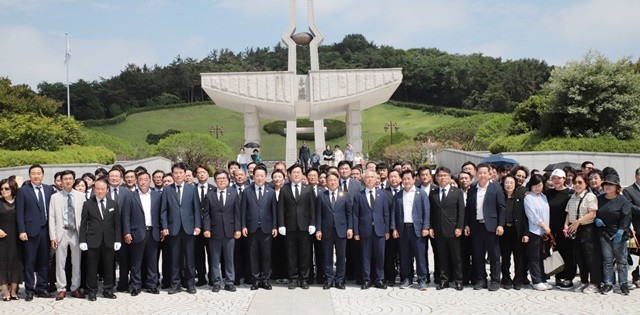박찬대 더불어민주당 전 원내대표가 28일 광주 북구 5·18 민주묘지를 참배하고 참석자들과 기념촬영을 하고 있다.