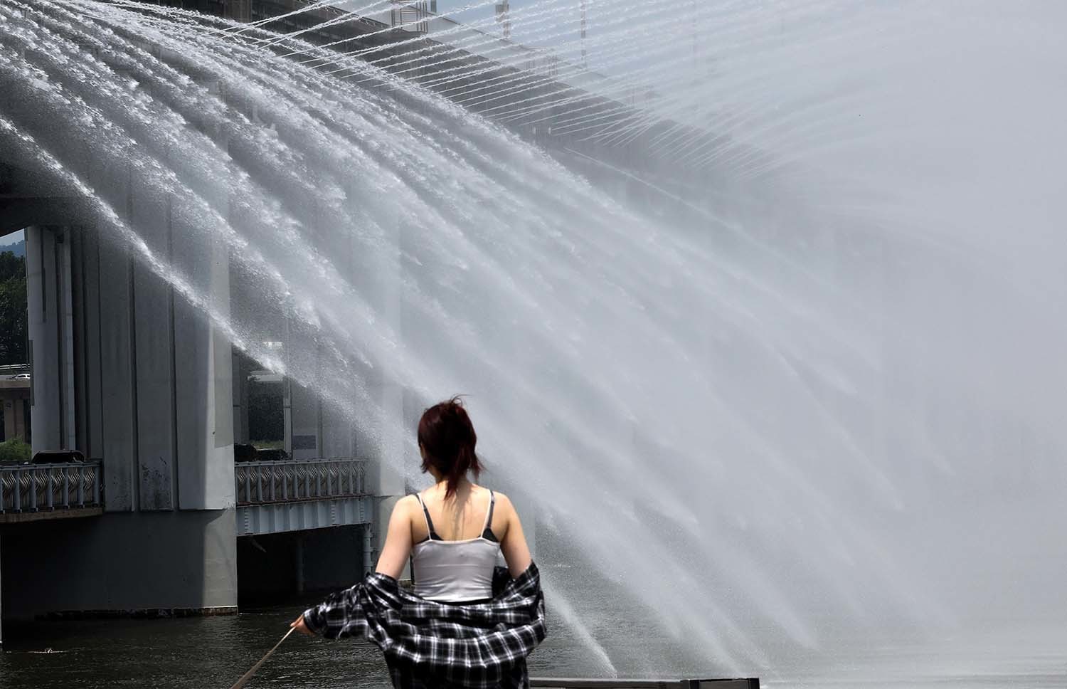 서울 전역에 폭염주의보가 발령된 30일 오후 서울 서초구 반포한강공원에서 시민들이 반포대교 달빛무지개분수를 바라보며 산책을 하고 있다.  / 뉴스1