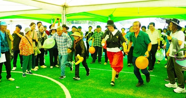 면민들이 그늘막에서 풍선터트리기 등 체육 행사를 즐기고 있다.