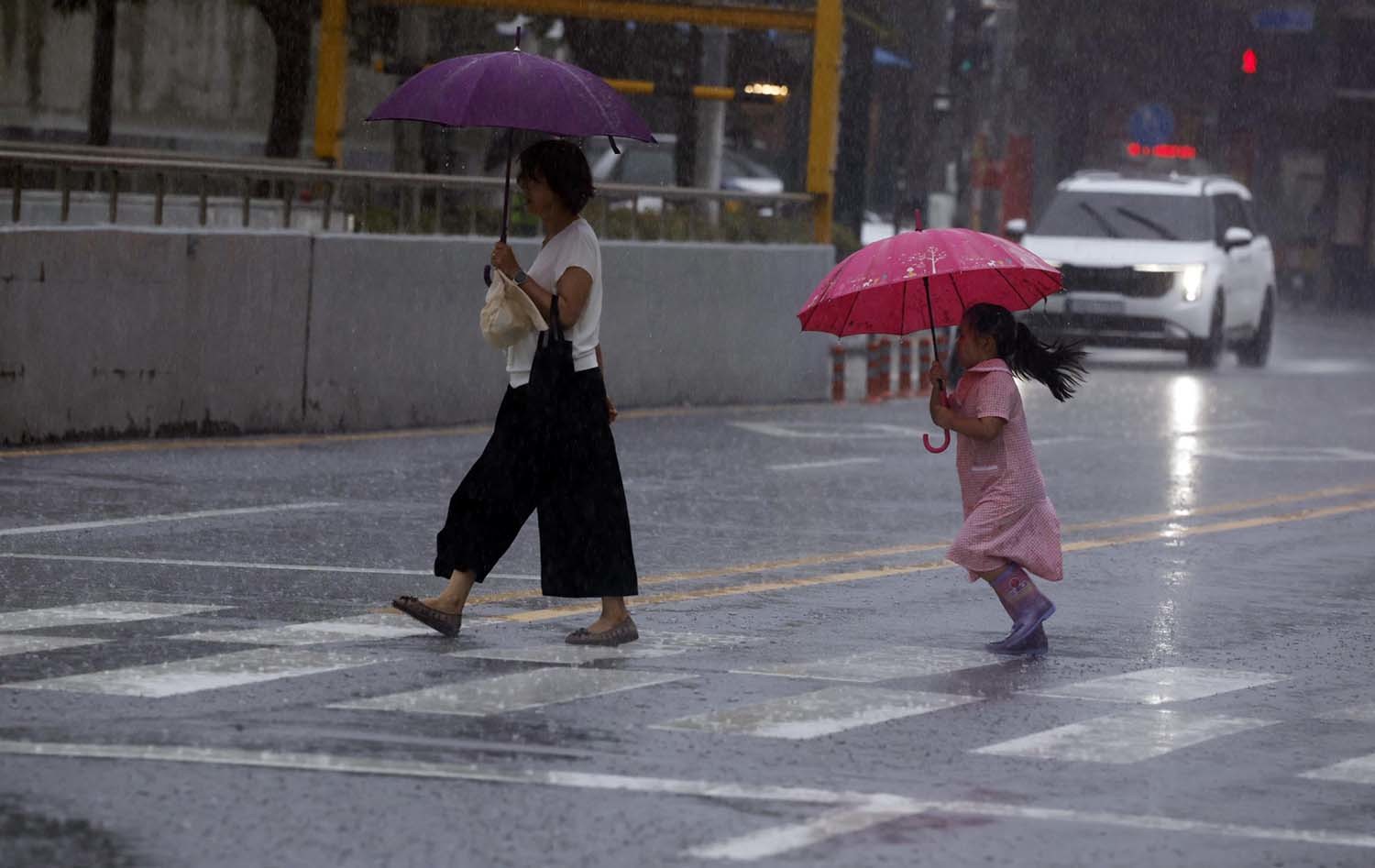 13일 광주전남 일부지역에 호우주의보가 발효된 가운데 동구 아시아문화전당 옆길에 시민들이 우산을 쓰며 걸어가고 있다. / 뉴스1