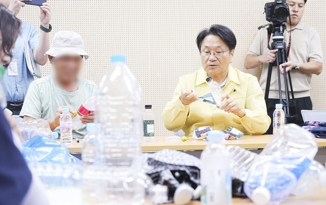 강기정 광주광역시장이 2024년 8월1일 오후 광산구 송정1동행정복지센터를 찾아 송정1동 자원재생활동단 어르신들과 투명페트병 라벨제거, 폐건전지 선별 등 재활용품 선별작업을 함께 하며 어르신들의 어려움을 듣고 있다./광주광역시 제공