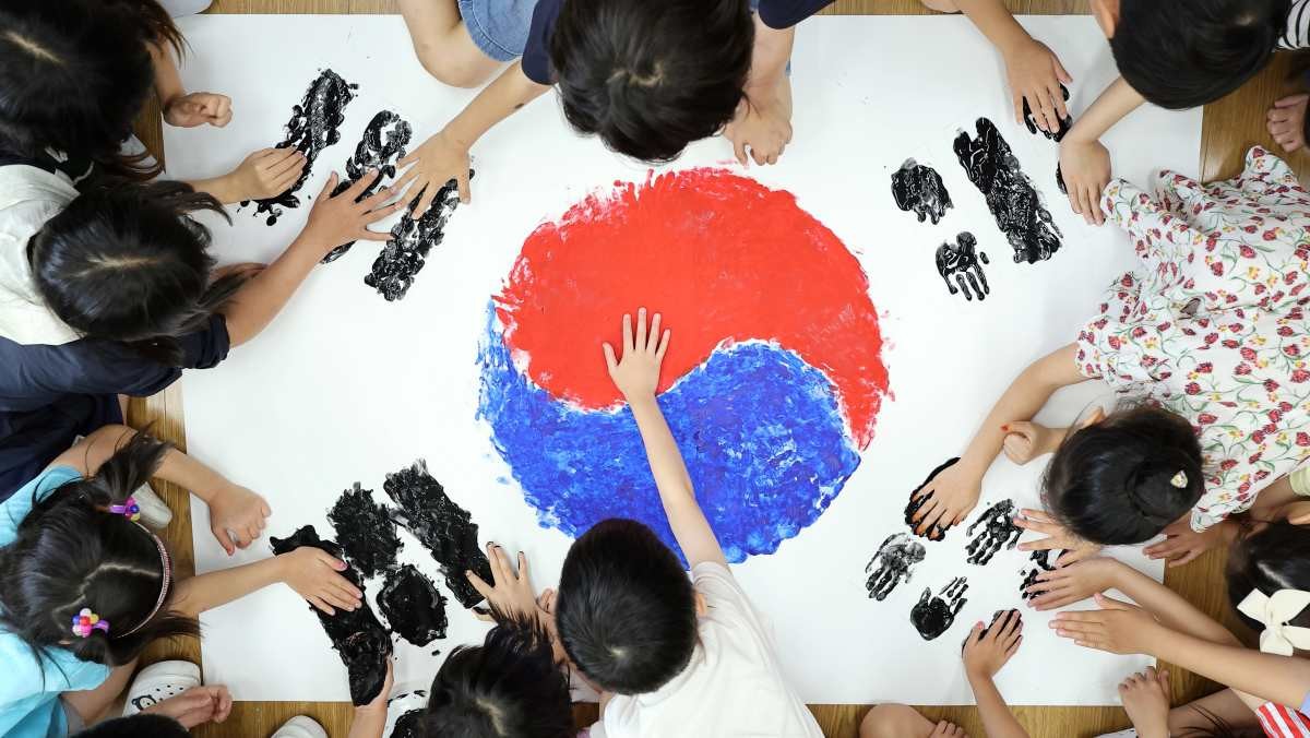 지난해 7월17일 제헌절을 맞아 경기도 수원시 영통구 영덕초등학교에서 어린이들이 물감으로 손도장 태극기를 그리고 있다 / 연합뉴스