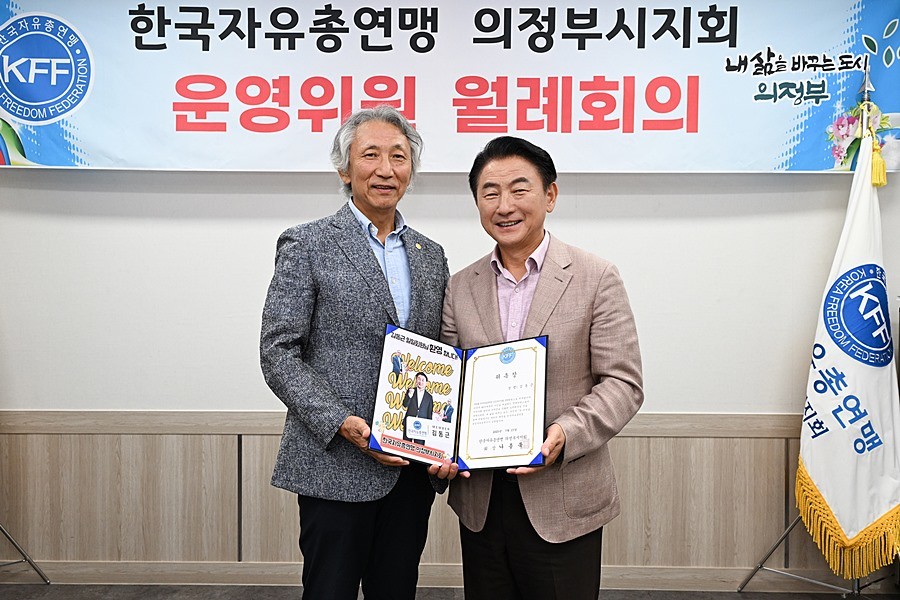 김동근 7월 17일 한국자유총연맹 의정부시지부 나종묵 회장에게 명예 위원 위촉장을 받은 뒤 함께 기념사진을 찍고 있다