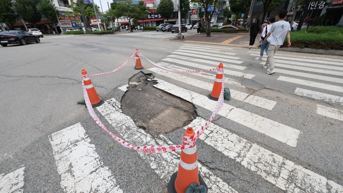 지난 18일 광주 북구 용봉동 북구청 사거리 일대 도로가 깨져 통제되고 있다. / 뉴스1