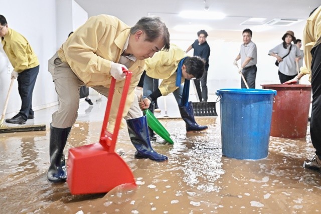 김이강 광주 서구청장이 21일 집중호우 침수 피해를 입은 서구 관내의 한 가구점에서 박찬대 더불어민주당 당대표 후보, 자원봉사자들과 복구 작업을 하고 있다. 광주 서구 제공