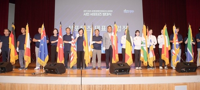 강기정 광주광역시장이 22일 오후 시청 대회의실에서 열린 ‘광주 2025 세계양궁선수권대회 시민 서포터즈 발대식’에 참석해 광주시양궁선수단과 함께 태극기 및 대회홍보기, 참여국가 국기 등을 들고 입장한 후 참석자들과 함께 기념촬영을 하고 있다. /광주광역시 제공