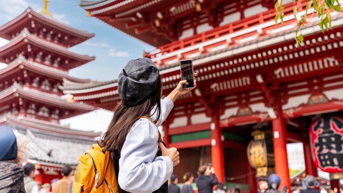 일본 도쿄 아사쿠사 구 센소지 사원 사진을 찍고 있는 젊은 여성 관광객. / kitzcorner-shutterstock.com