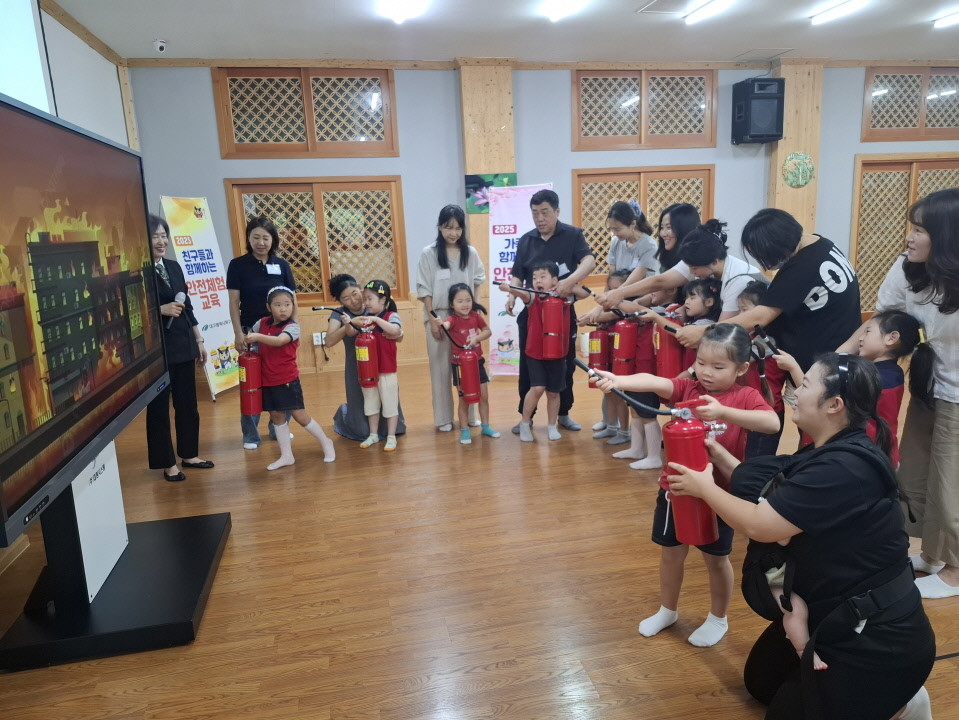대구 북구 지역 내 유치원에 등원하는 어린이와 학부모들이 가족과 함께하는 안전체험교육에 참여해 소화기 사용법을 배우고 있다. / 대구 북구 제공