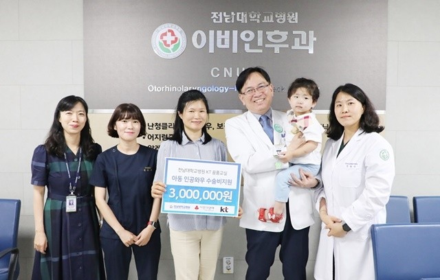 전남대병원 공공보건의료사업팀이 KT지정기탁사업 및 전남대병원 발전후원회와 연계해 이동이(왼쪽에서 다섯 번째) 아동과 어머니 최희영(왼쪽에서 세 번째)씨에게 수술비와 치료비를 지원한 후 기념사진을 촬영하고 있다.