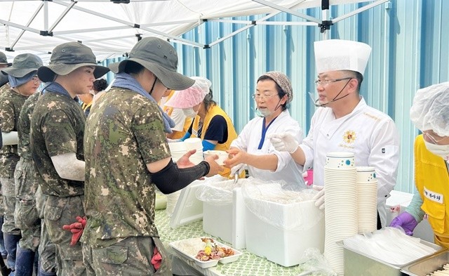 안유성 셰프(오른쪽)가 군장병과 주민들에게 음식을 전달하고 있다.