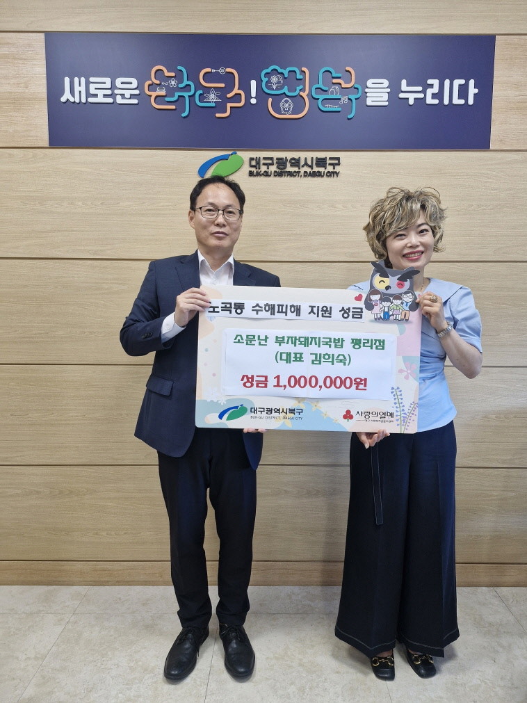 소문난 부자돼지국밥 대구 평리점 김희숙 대표(오른쪽)가 30일 수해 피해 이웃돕기 성금 100만원을 대구 북구청에 전달하고 지형재 북구 부구청장과 기념촬영을 하고 있다. / 대구 북구청 제공