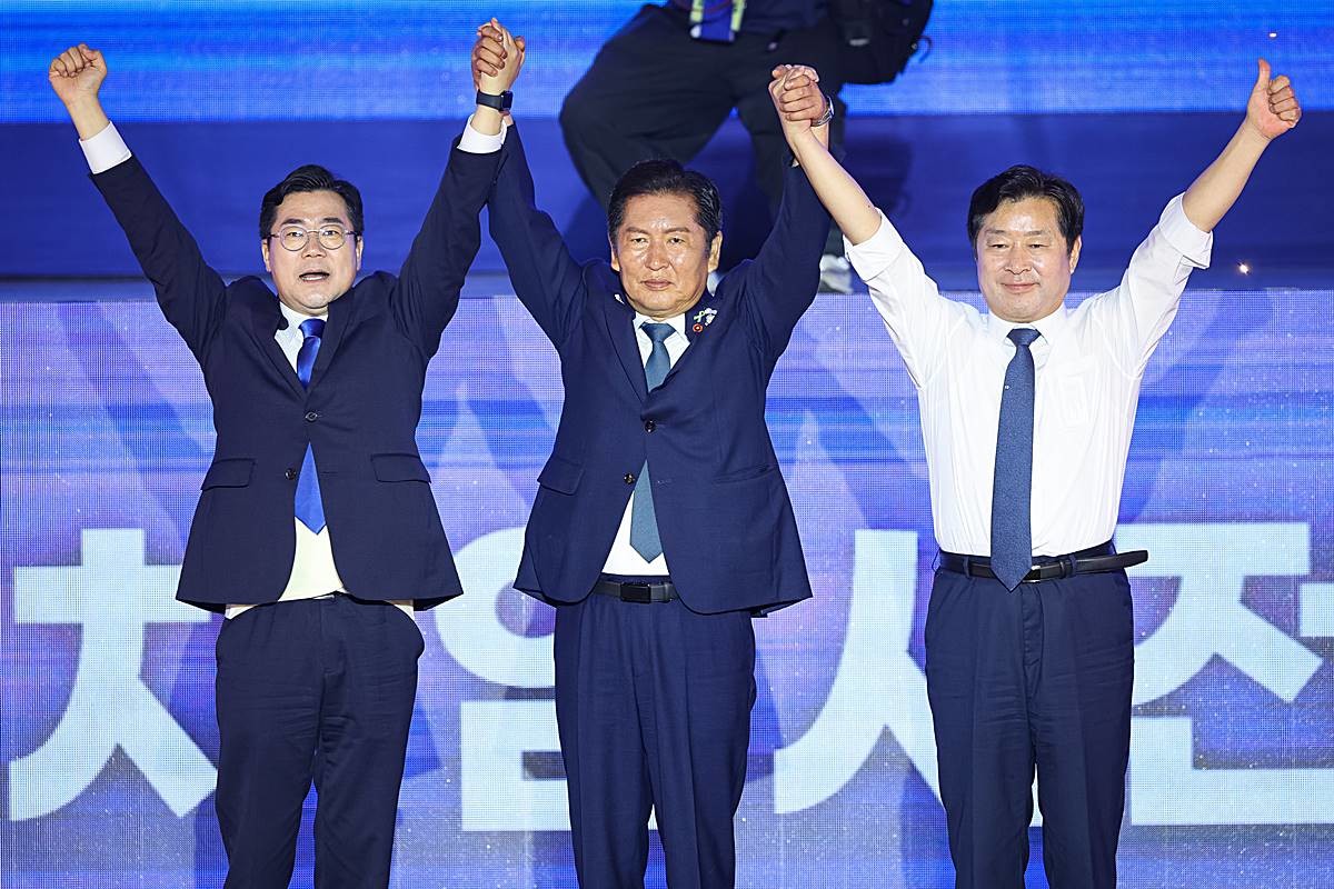 정청래 더불어민주당 신임 당대표와 황명선 최고위원이 지난 2일 경기 고양시 킨텍스에서 열린 제2차 임시전국당원대회에서 당선 발표 후 당원들을 향해 손을 들어 보이고 있다. 왼쪽은 박찬대 당대표 후보 / 뉴스1