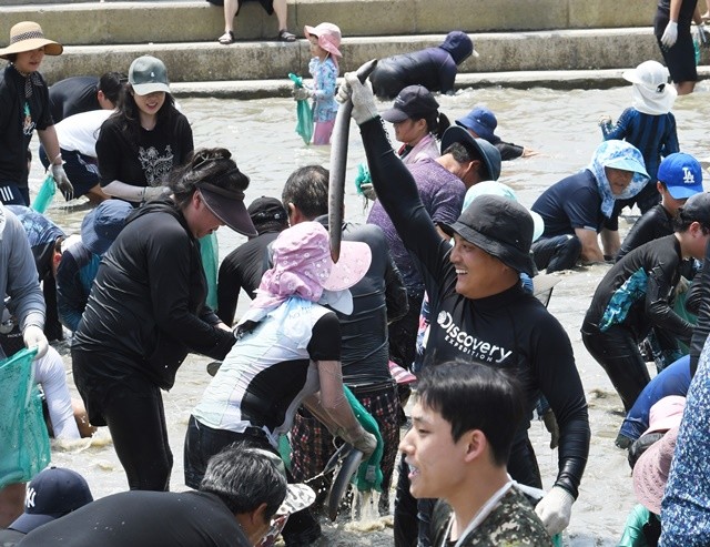 함평돌머리해수욕장에서 열린 장어잡기 체험행사에 참여한 피서객이 장어를 잡고 즐거워하고 있다. / 노해섭 기자