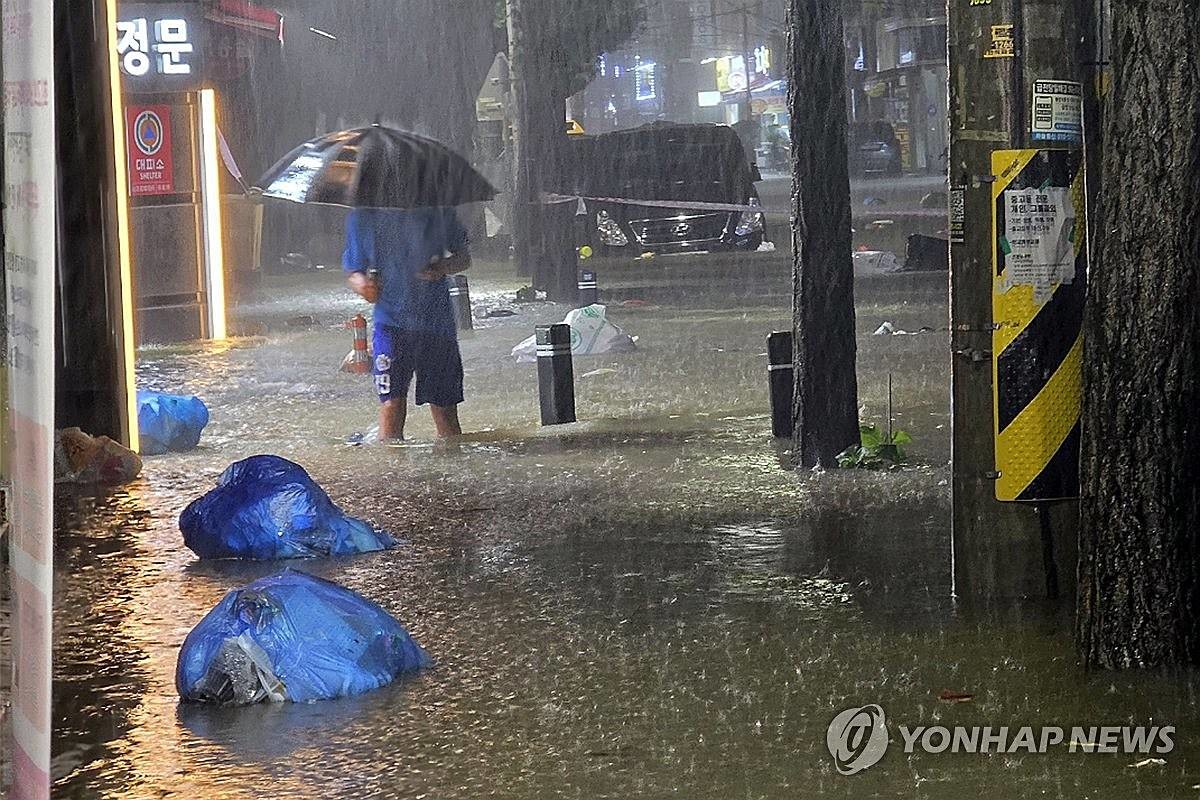무안군을 중심으로 광주·전남 곳곳에 극한호우가 쏟아진 지난 3일 오후 광주 북구 운암동 도심에서 한 시민이 침수된 거리를 이동하고 있다 / 연합뉴스
