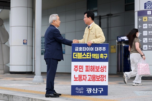 지난 6월 광주송정역 앞 광장에서 금호타이어 화재와 관련한 더블스타 책임 촉구 1인 시위에 나선 박병규 광산구청장이 길을 지나다 응원을 보낸 시민과 악수를 나누고 있다.