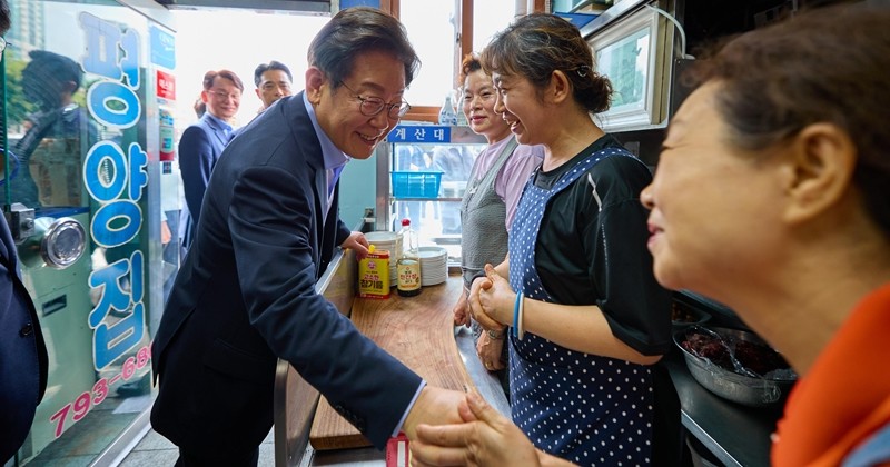 이재명 대통령이 7월 31일 서울 용산 대통령실 인근 식당에서 강훈식 비서실장을 비롯한 참모진들과 점식식사를 마친 후 상인들과 인사를 나누고 있다. / 뉴스1