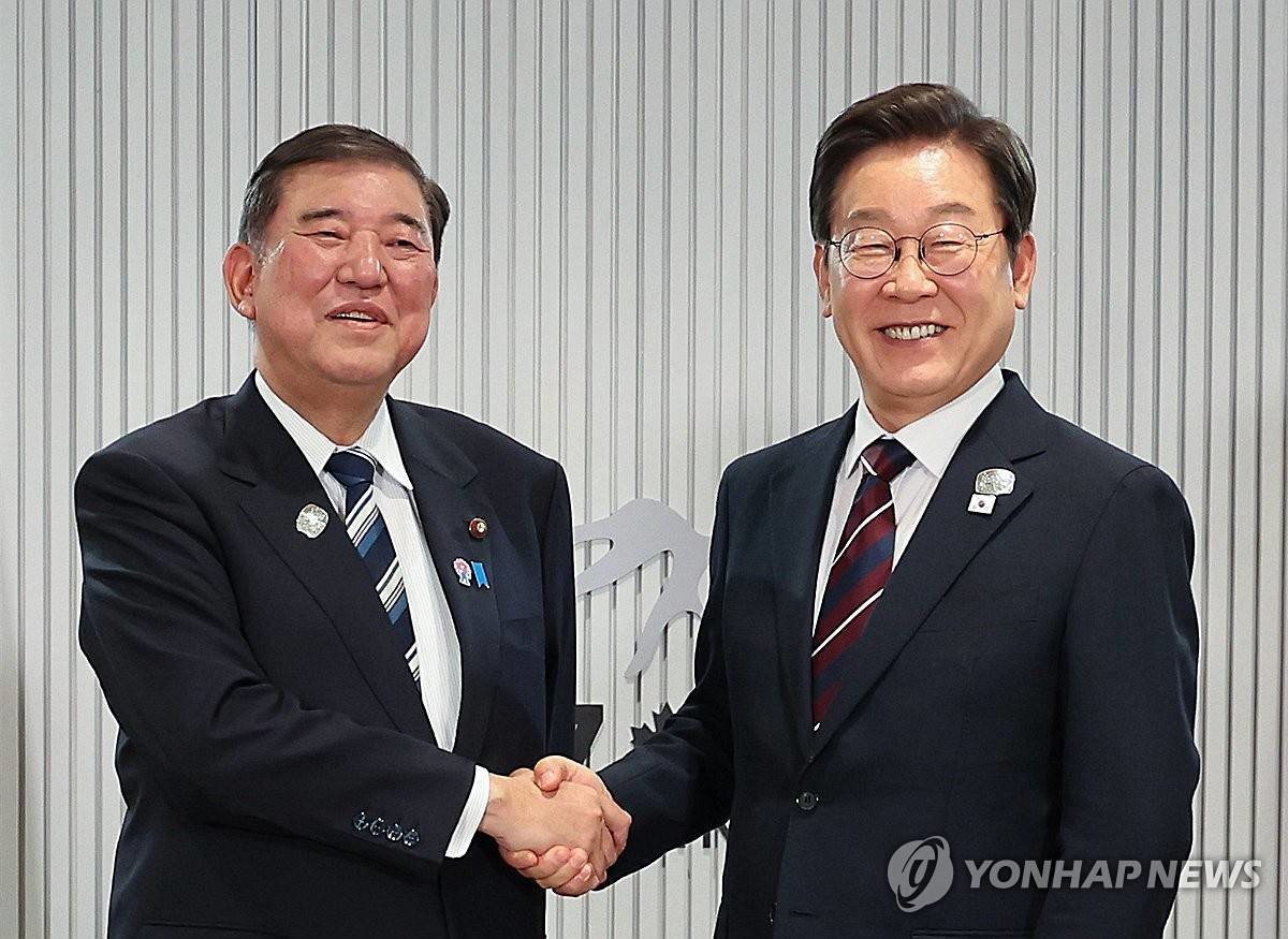 이재명 대통령이 지난 6월 17일(현지시간) 캐나다 앨버타주 캐내내스키스 주요 7개국(G7) 정상회의장에서 열린 한일 정상회담에서 이시바 시게루 일본 총리와 악수하며 기념촬영을 하고 있다 / 연합뉴스