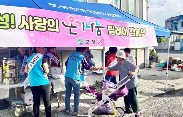 보성군 조성면 봉사단체가 조성 5일장에서 ‘사랑의 온기나눔 릴레이 캠페인’ 행사를 열고 주민들에게 시원한 음료를 나누고 있다.