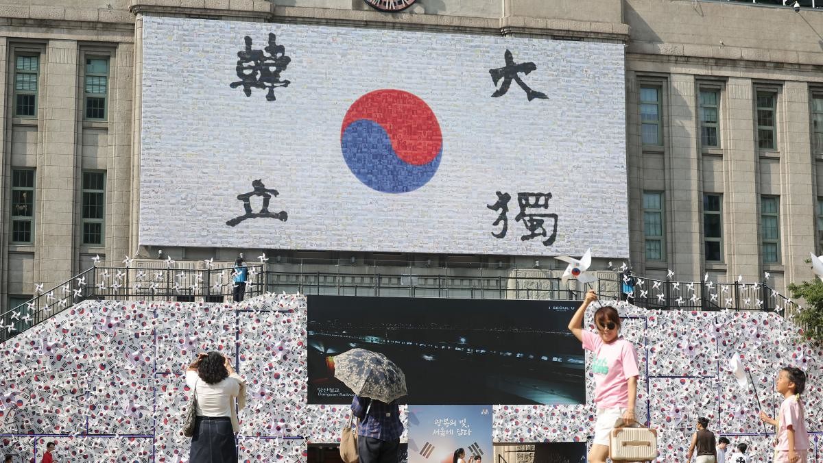 광복 80주년을 앞둔 10일 서울도서관 정문에 설치된 태극기 언덕 앞을 시민들이 지나고 있다. / 연합뉴스