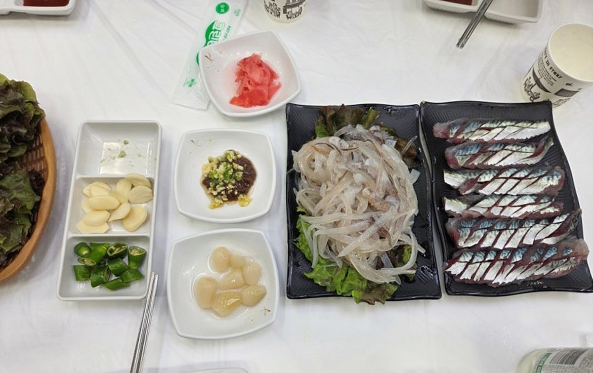 네티즌 A 씨가 속초 오징어난전 앞 횟집에서 구매했다고 밝힌 2만 원짜리 오징어 두 마리(회)와 서비스 회 모습. 오징어난전 메뉴의 가격 수준과 비교하기 위해 올린 사진이다. / 속초시청 자유게시판