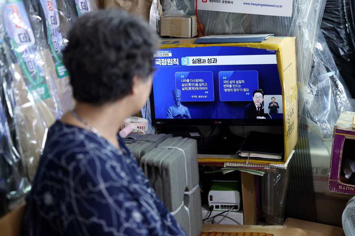 13일 오후 서울 도심의 한 전통시장에서 상인이 국정기획위원회 국민보고대회 '국민이 주인인 나라 함께 행복한 대한민국’ 생중계를 지켜보고 있다. / 뉴스1