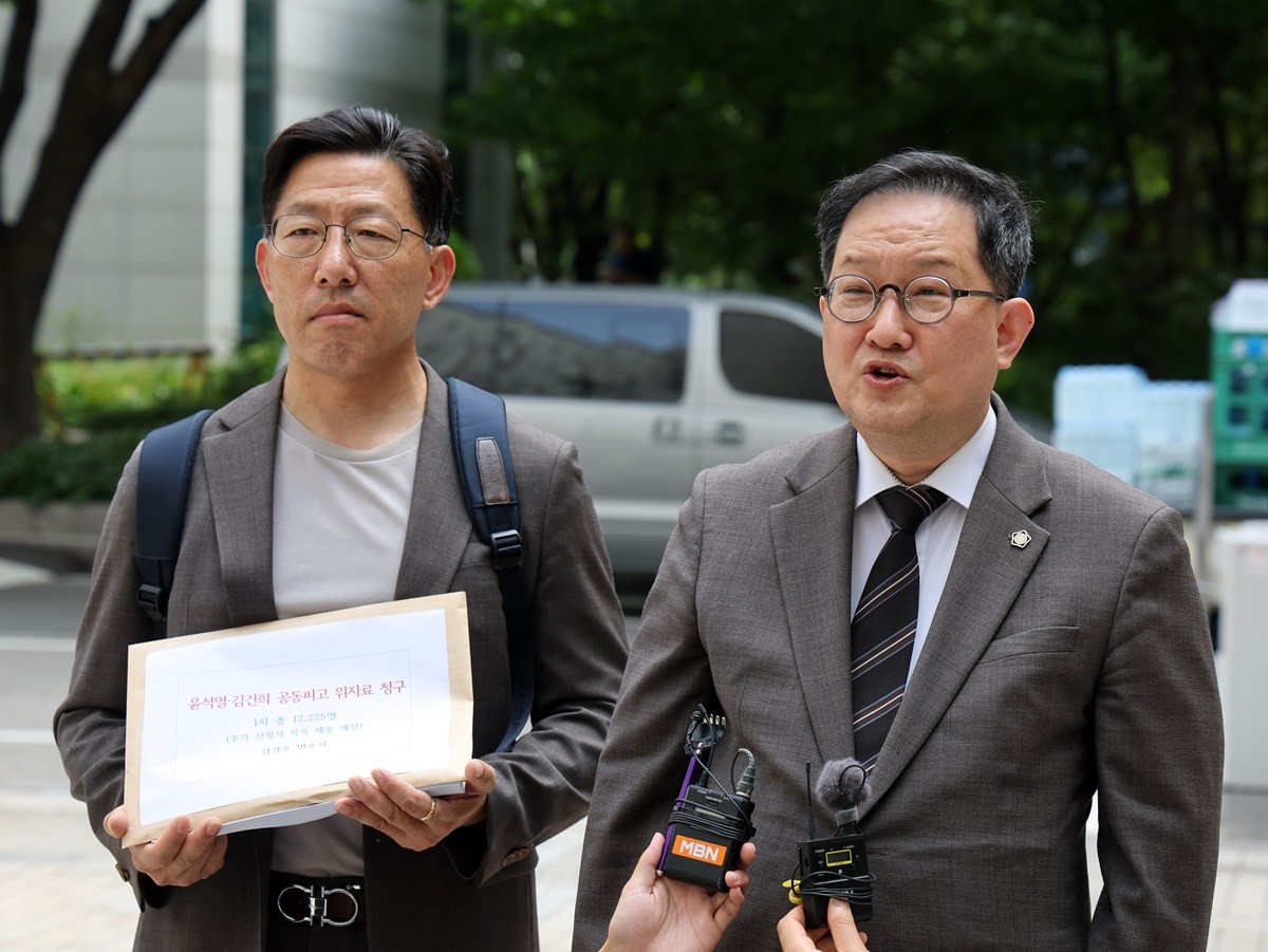 김경호 변호사(오른쪽)가 18일 오전 서울 서초구 서울중앙지방법원에서 윤석열 전 대통령과 부인 김건희 여사를 공동피고로하는 위자료 청구 소장 제출 전 취재진 질문에 답하고 있다. 이날 김 변호사는 1만 2224명을 대리해 윤 전 대통령과 김 여사를 상대로 원고 1인당 각 10만 원 위자료를 청구하는 소장을 중앙지법에 제출했다. / 뉴스1