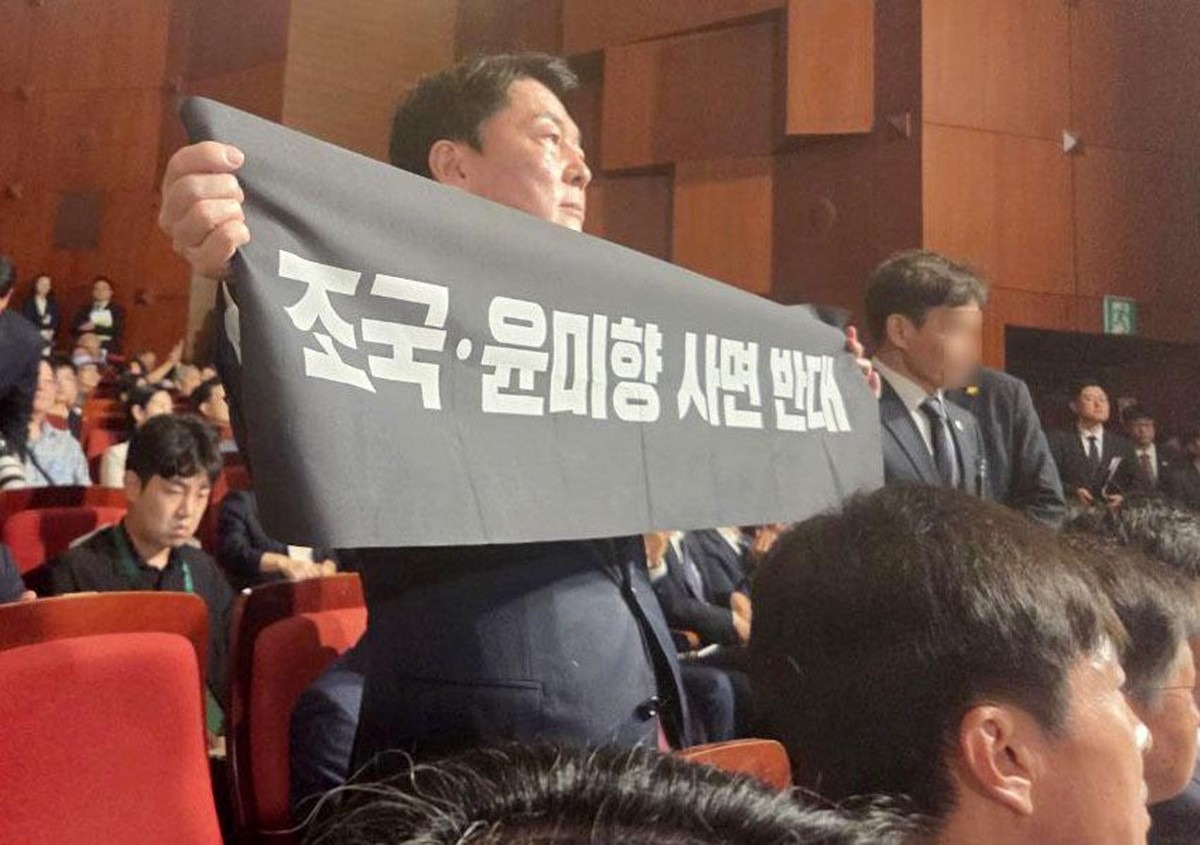 안철수 국민의힘 당대표 후보가 15일 서울 종로구 세종문화회관에서 열린 제80주년 광복절 경축식에 참석해 경축사 중인 이재명 대통령을 향해 조국 전 조국혁신당 대표와 윤미향 전 의원의 사면 반대 플래카드를 들어 보이며 항의하고 있다. / 안철수 캠프