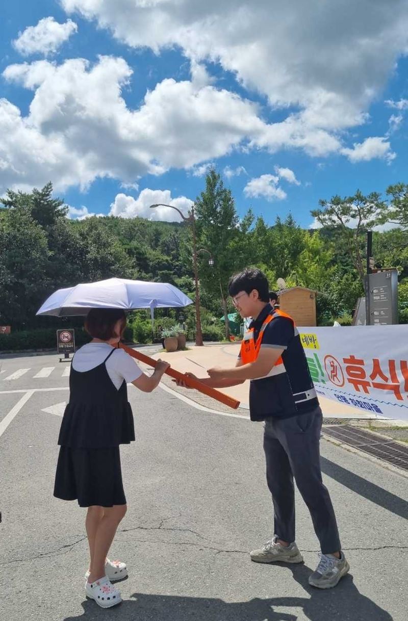 안동빛드림본부 직원이 하회마을을 찾은 관광객에게 양산을 나눠주고 있다 / 한국남부발전 제공