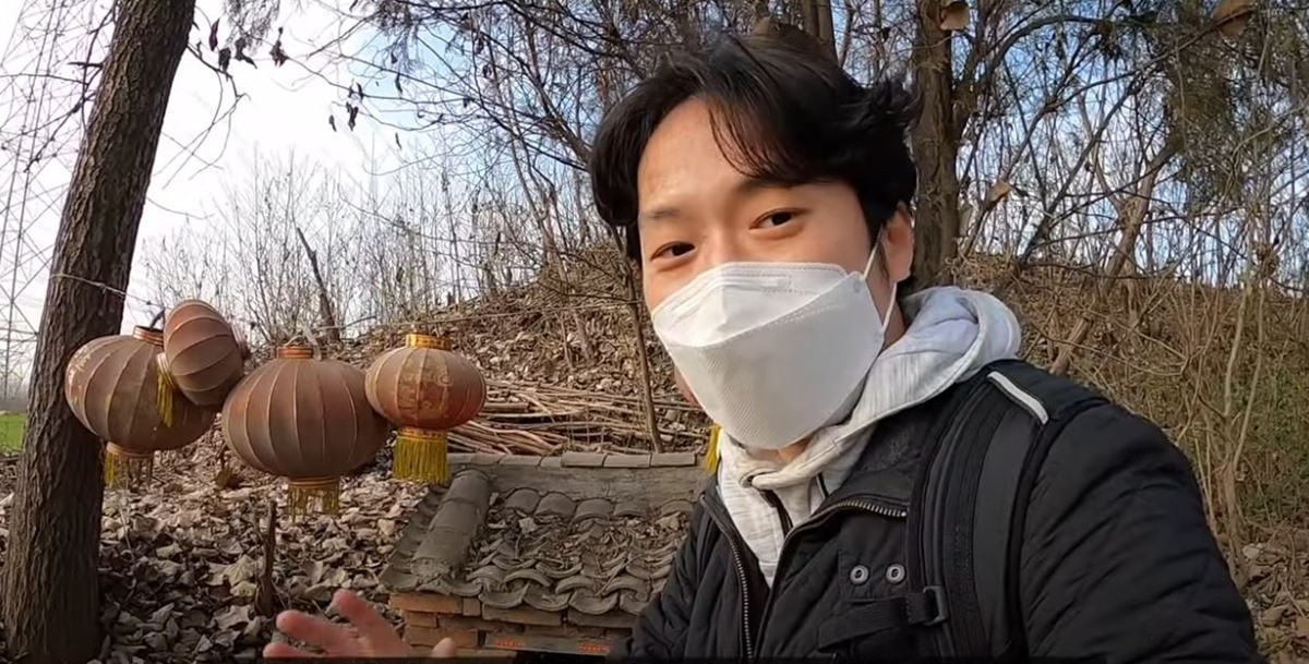 황량한 중국 후한말 명장 여포 무덤 앞에서 포즈를 취한 유튜버, / 유튜브 채널 '기행장군 양양이'