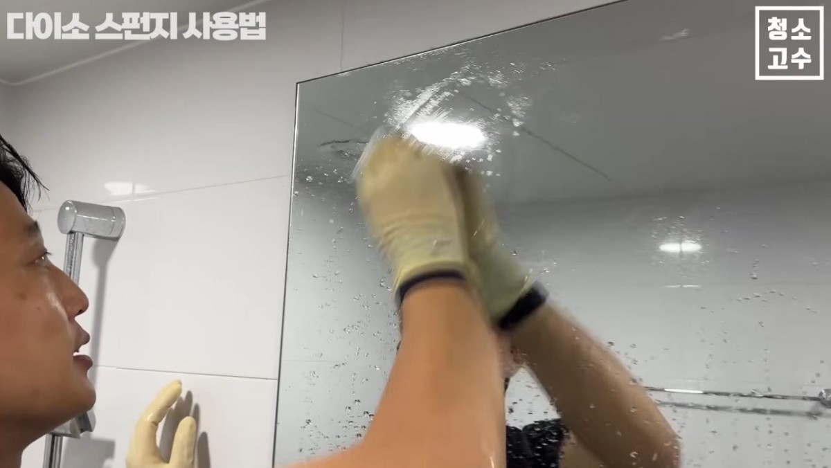 유튜브 '청소고수' 이팀장이 다이소 제품으로 거울 물때를 제거하는 모습. / 유튜브 '청소고수'