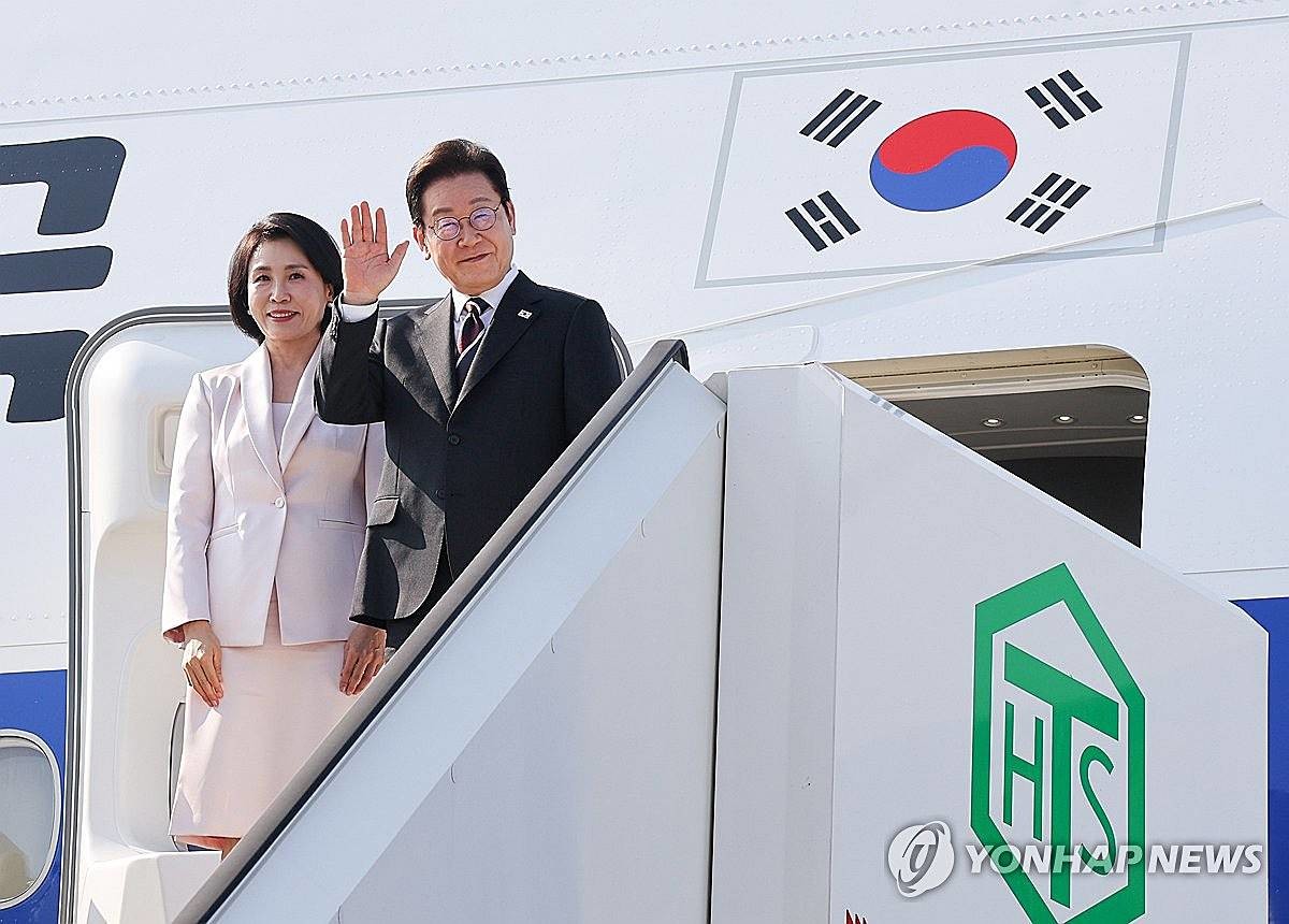 한일 정상회담을 마친 이재명 대통령과 부인 김혜경 여사가 24일 일본 도쿄 하네다공항에서 도널드 트럼프 미국 대통령과의 한미 정상회담을 위해 워싱턴DC로 향하며 공군1호기에 올라 인사하고 있다 / 연합뉴스