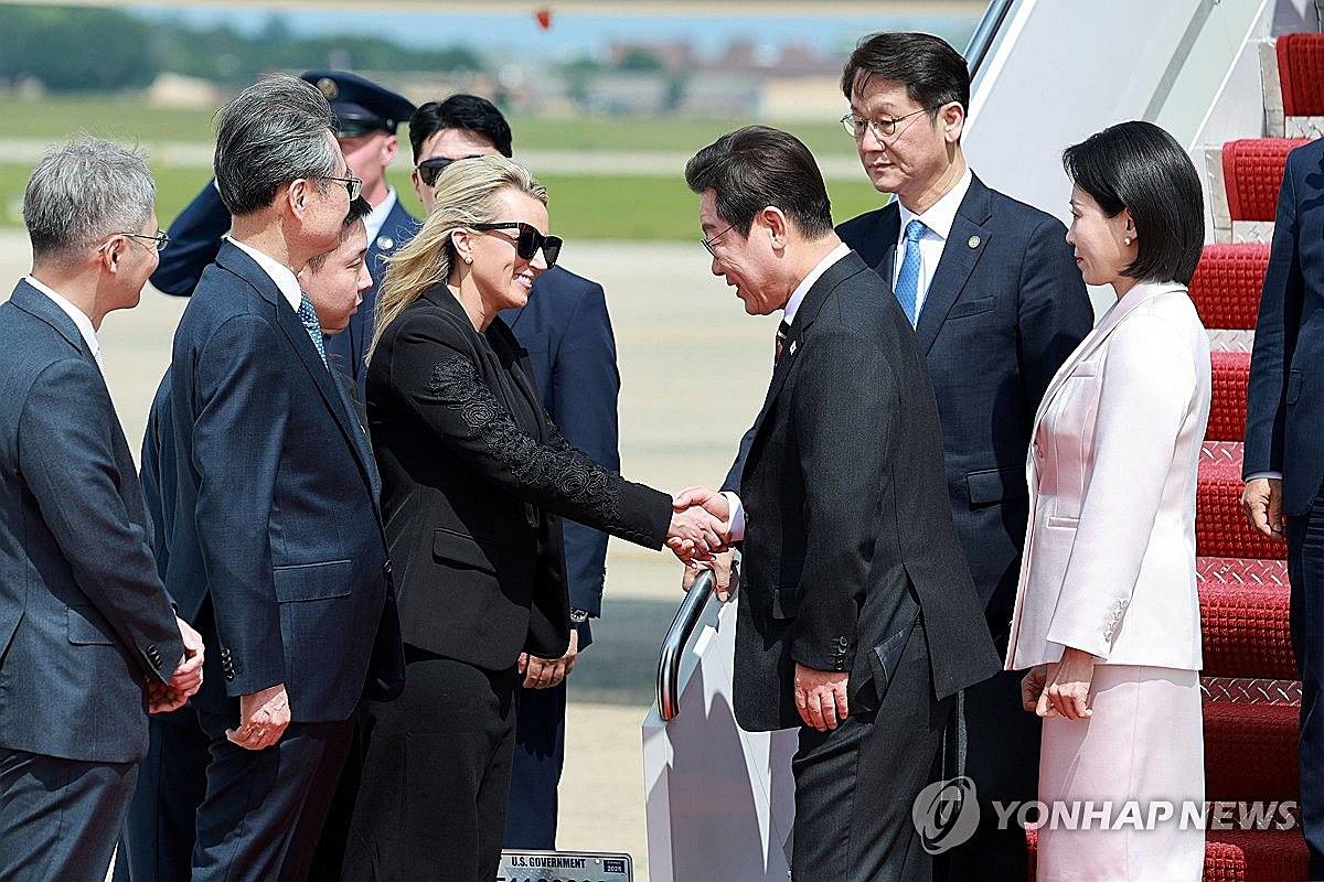 이재명 대통령과 김혜경 여사가 24일(현지시간) 미국 워싱턴DC 인근 앤드루스 합동기지에 도착해 영접 나온 미국 측 애비 존스 부의전장과 인사하고 있다 / 연합뉴스