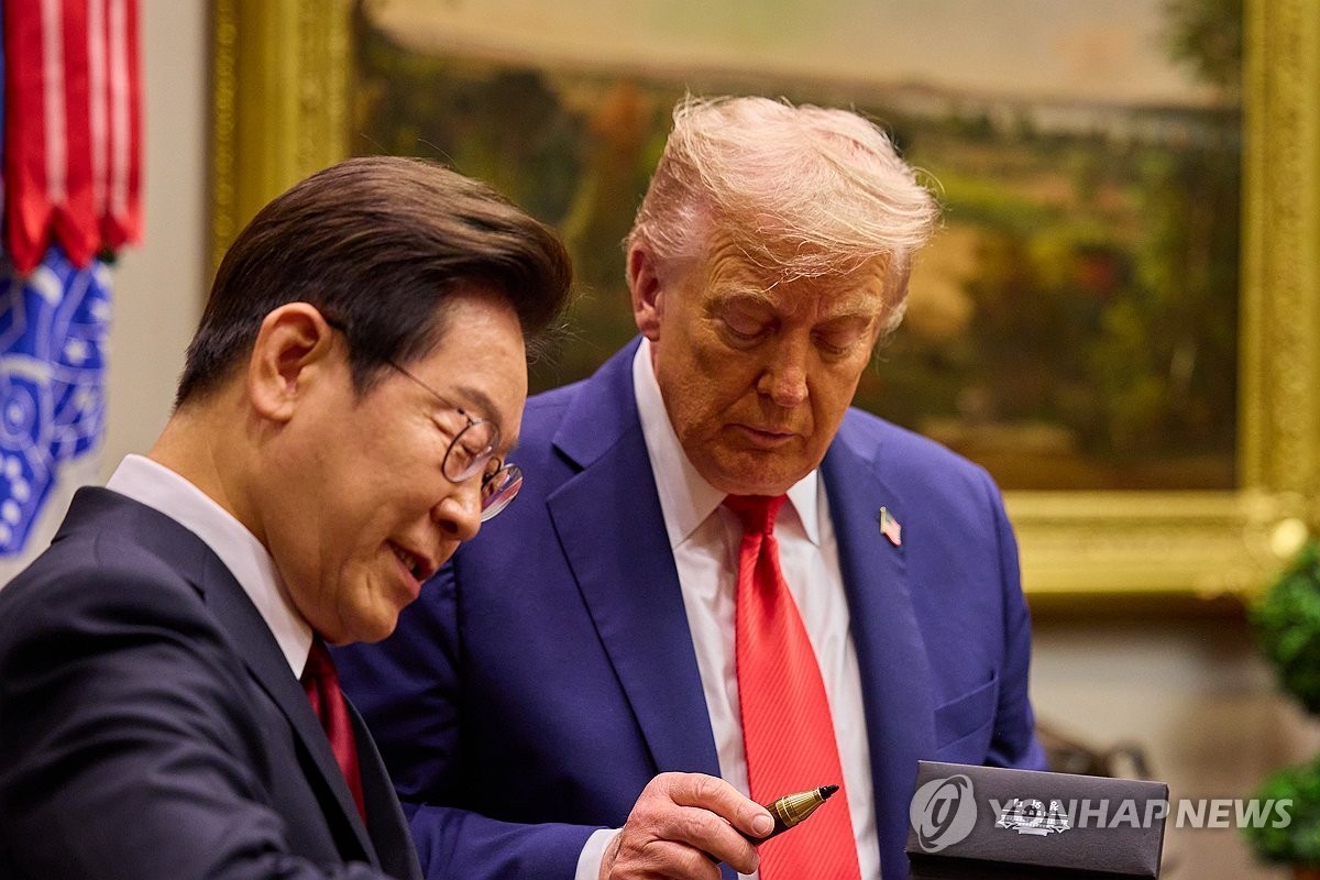 이재명 대통령이 25일(현지시간) 미국 워싱턴DC 백악관에서 열린 한미 정상회담에서 도널드 트럼프 미국 대통령에게 방명록 작성 때 쓴 펜을 선물하고 있다. 국산펜이다. / 연합뉴스