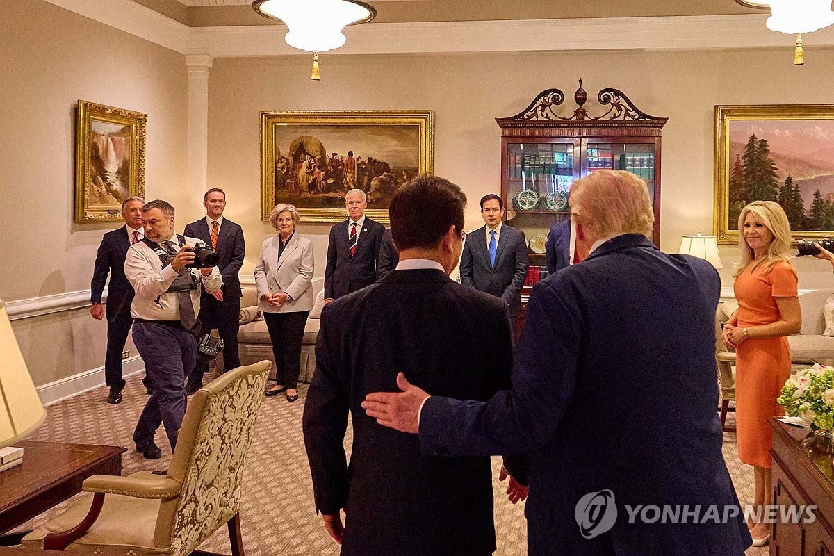 이재명 대통령이 25일(현지시간) 미국 워싱턴DC 백악관에서 열린 한미 정상회담에 앞서 도널드 트럼프 미국 대통령과 함께 미국 측 수행원들을 소개받기 위해 이동하고 있다. / 연합뉴스