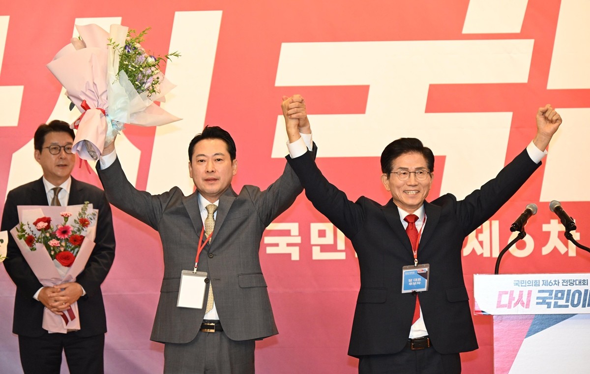 국민의힘 대표로 선출된 장동혁 후보와 탈락한 김문수 후보가 26일 국회 도서관에서 열린 전당대회 결선장에서 지지자들에게 인사하고 있다. / 뉴스1